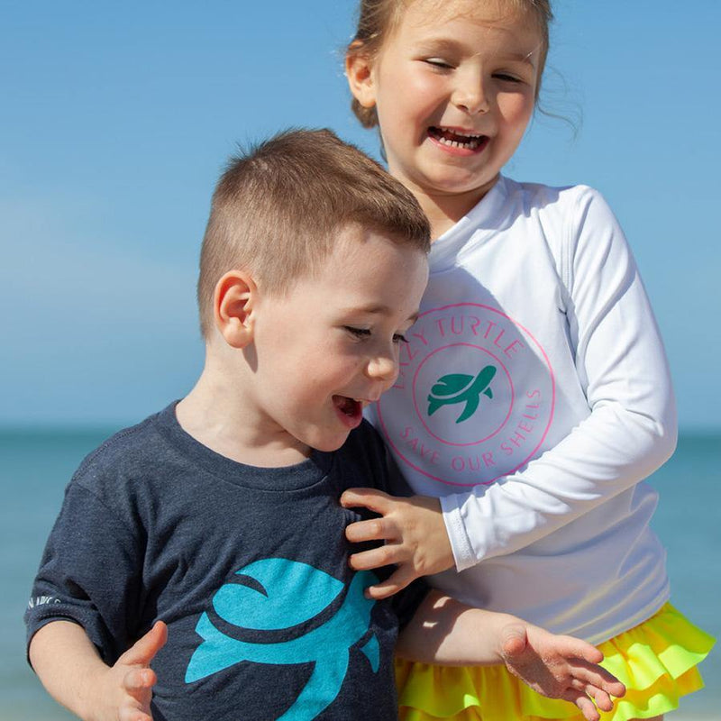 Boy wearing Lizzy Tee on beach with girl
